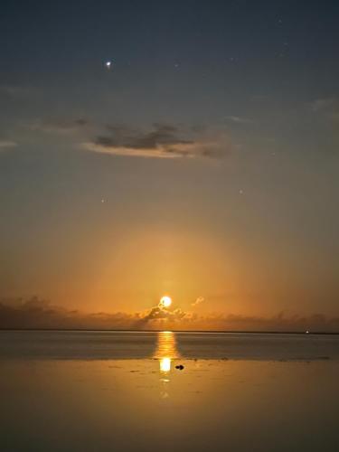- un coucher de soleil sur la plage dans l'établissement Teraupoo Lodge Maison, à Afareaitu