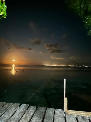 a view of the ocean from a dock at sunset at Teraupoo Lodge Maison in Afareaitu