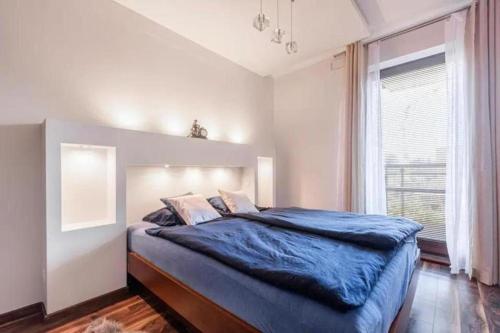 una camera da letto con un grande letto con una coperta blu di UrbanNestGroup & Sz 5/28 a Danzica