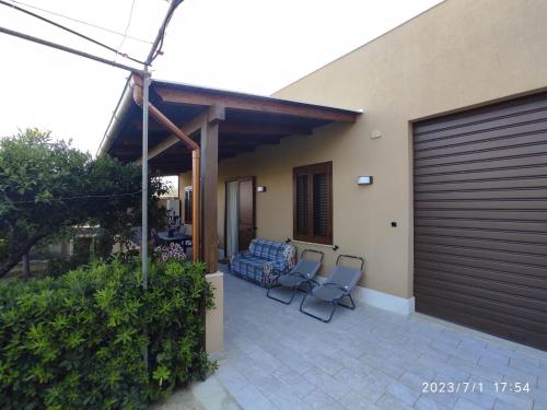 two chairs sitting on a patio next to a house at House & Garden in Rilievo