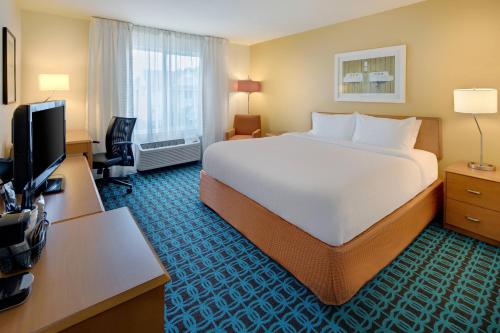Habitación de hotel con cama grande y TV en Fairfield Inn & Suites Indianapolis Airport, en Indianápolis