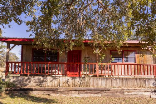a house with a red door and a fence at Hi-Line Resort in Tow