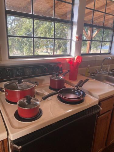three pots and pans on a stove in a kitchen at Hi-Line Resort in Tow