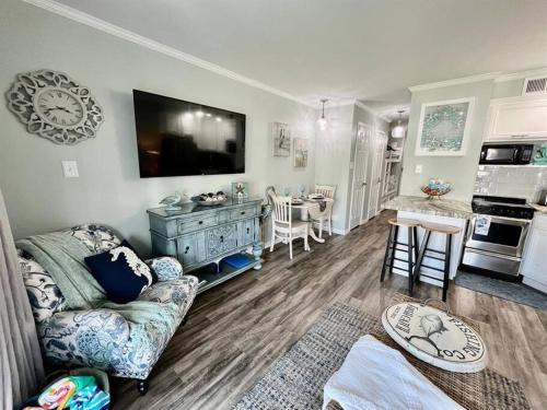 a living room with a couch and a flat screen tv at Casa Del Marlin - Your Beach Retreat on Galveston Island, TX in Galveston
