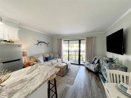 a kitchen and living room with a couch and a refrigerator at Casa Del Marlin - Your Beach Retreat on Galveston Island, TX in Galveston