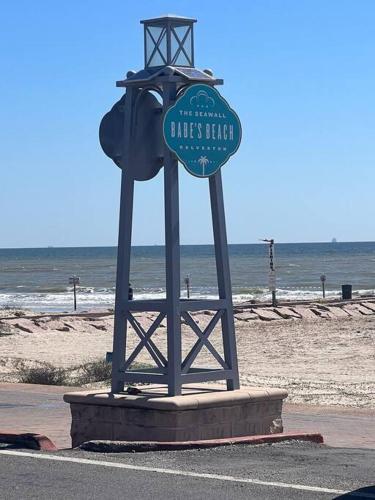 a sign on the beach next to the ocean at Casa Del Marlin - Your Beach Retreat on Galveston Island, TX in Galveston