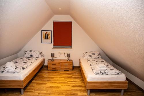 a attic room with two beds and a mirror at Ferienwohnungen Saida Wohnung 12 in Norden