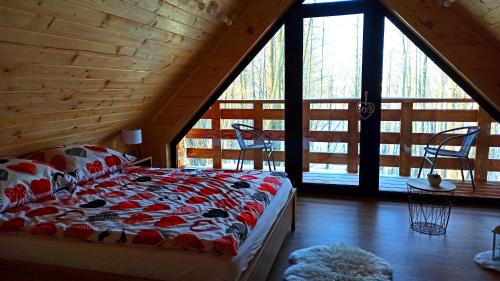 een slaapkamer met een bed in een blokhut bij Las Lorien - wynajem domków letniskowych 2.0 in Roczyny