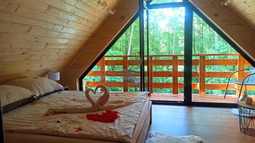 RoczynyにあるLas Lorien - wynajem domków letniskowych 2.0の大きな窓のある部屋のベッドにフラミンゴが2台置かれています。