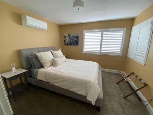 a bedroom with a bed with a nightstand and two windows at Newly remodeled condo in Groveland