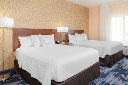 a hotel room with two beds with white sheets at Fairfield Inn & Suites by Marriott Augusta Washington Rd./I-20 in Augusta