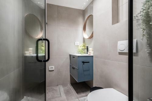 La salle de bains est pourvue d'une douche et de toilettes avec deux miroirs. dans l'établissement At Kidan's, à Jérusalem