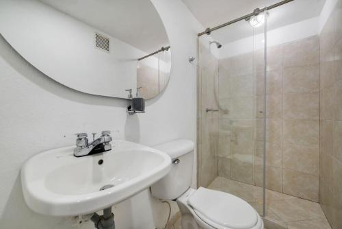 een badkamer met een toilet, een wastafel en een douche bij Amplios departamentos en Envigado in Envigado