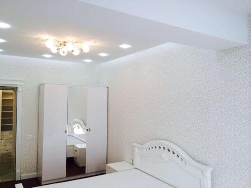 a bedroom with a white bed and a mirror at The Park Azure Residence - Baku in Baku