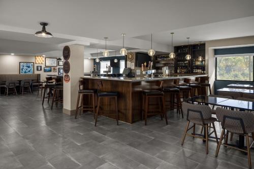 a restaurant with a bar with chairs and tables at Four Points by Sheraton Newark Christiana Wilmington in Newark