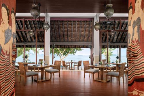 a restaurant with tables and chairs and a view of the ocean at Phulay Bay, A Ritz-Carlton Reserve in Tab Kaek Beach
