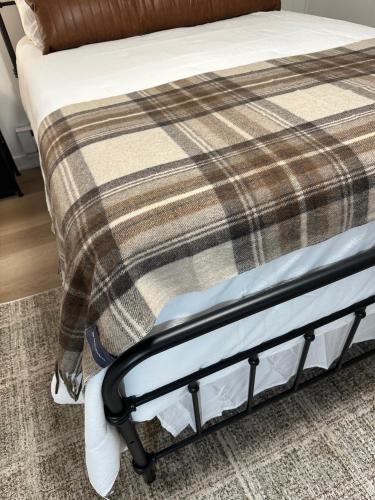 a bed frame with a plaid blanket on it at Rockwell Commons 