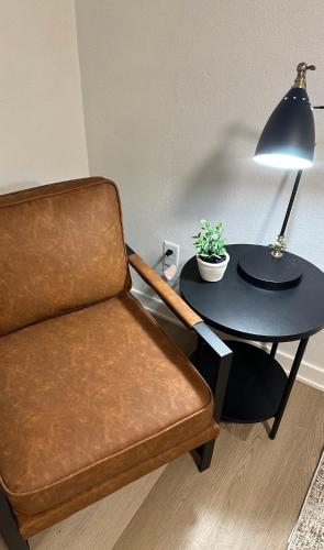 un soggiorno con sedia e tavolo con lampada di Rockwell Commons 
