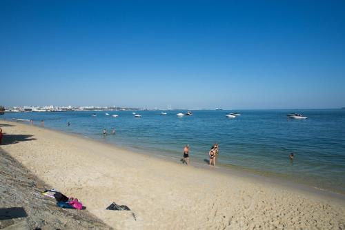 a group of people walking on the beach at Hotel Solaris in Setúbal