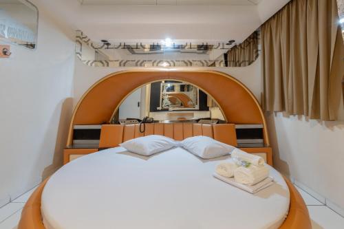 聖保羅的住宿－Motel Disco Verde Congonhas 4，卧室配有带毛巾的大型白色床