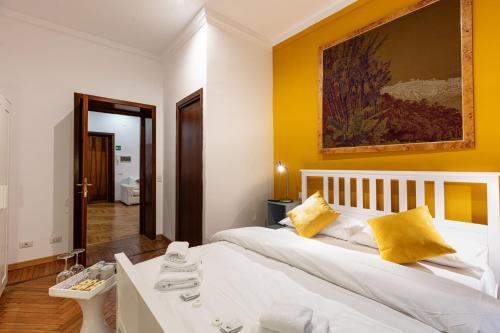 um quarto com uma cama branca e paredes amarelas em Passeggiata al Vaticano em Roma
