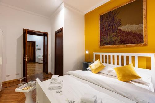 a bedroom with a white bed with yellow walls at Passeggiata al Vaticano in Rome