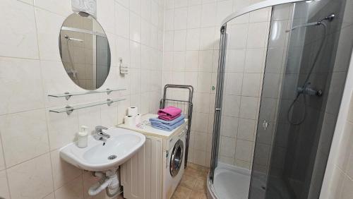 a white bathroom with a sink and a shower at Апартаменти з прекрасним панорамним видом на замок та гори in Mukacheve