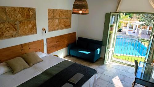 a bedroom with a bed and a chair and a balcony at Hostal Residencia Alma in Port d'Alcudia