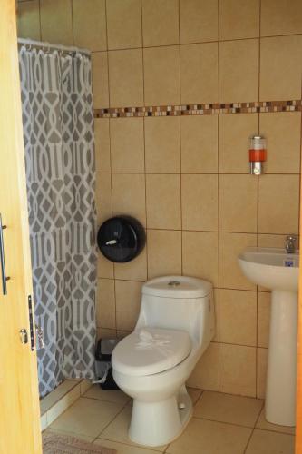a bathroom with a toilet and a sink at Bungalows Paraíso Celeste in Bijagua