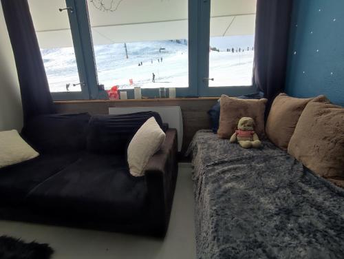 un ours en peluche assis sur un canapé dans un salon dans l'établissement Studio Cosy 2100m pied des pistes-Direct to SKI slopes-SKI in SKI out-LA PLAGNE AIME 2000, à Aime La Plagne