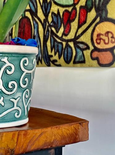 a vase sitting on a wooden table next to a painting at Hotel Casa Paradiso Guarujá in Guarujá
