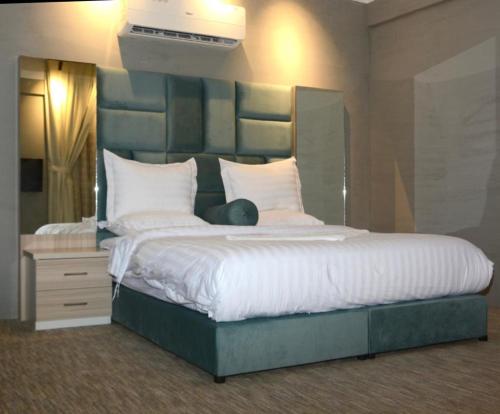 een slaapkamer met een groot bed met witte kussens bij أجنحة هدوء الفندقية in Riyad