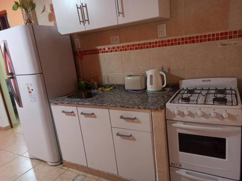 uma cozinha com um fogão branco e um frigorífico em Nuevo Amanecer en San Fdo del Valle de Catamarca em San Fernando del Valle de Catamarca