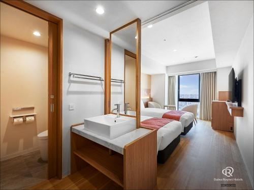Letto o letti in una camera di Daiwa Roynet Hotel NAHA-OMOROMACHI PREMIER