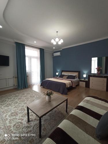 ein großes Schlafzimmer mit 2 Betten und einem Tisch in der Unterkunft Однокомнатные апартаменты в золотом квадрате ЖК GREEN PLAZA in Aqtau