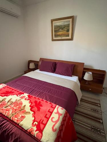 a bedroom with a large bed with purple sheets at Maison d'hôtes DAR DRISS in Matmata