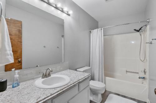 ein weißes Bad mit einem Waschbecken und einem WC in der Unterkunft Spacious Townhouse Finished Basement in Toledo