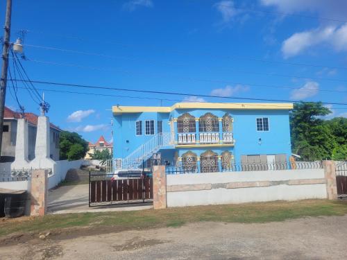 聖瑪麗的住宿－Sunshine D，前面有白色围栏的蓝色房子