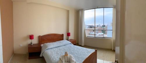 a bedroom with a bed and a large window at Central boutique Trujillo in Trujillo