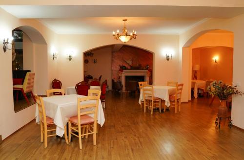 a dining room with tables and chairs and a fireplace at Vila Arber in Golem
