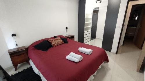 een slaapkamer met een rood bed en handdoeken erop bij Cara Sur Bariloche in Bariloche