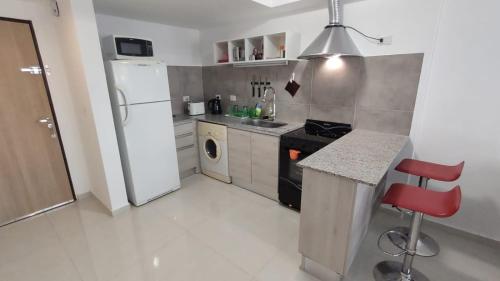 een keuken met een witte koelkast en een fornuis bij Cara Sur Bariloche in Bariloche