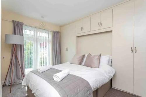 a bedroom with a large bed and a window at Beautiful Modern Home - Free Parking & Long Stays in Blackpool