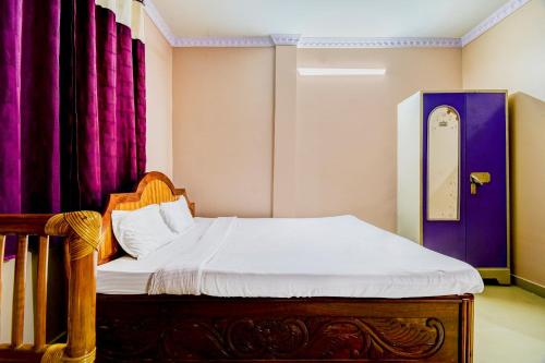 Bett in einem Zimmer mit lila Vorhängen in der Unterkunft Ekora Resort in Hatikhuli
