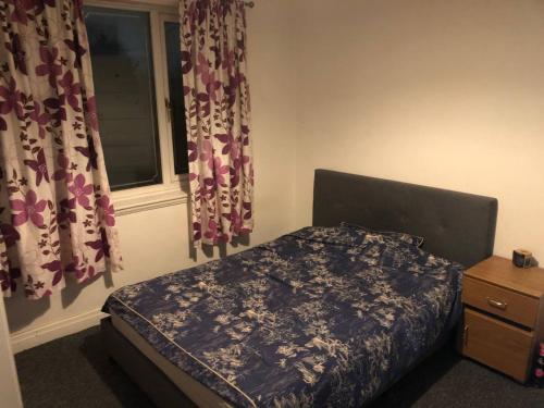 a bedroom with a bed and a window with curtains at Comfy keats place in Bushbury