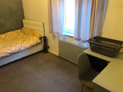 a bedroom with a bed and a desk and a window at Comfy keats place in Bushbury