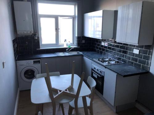 a kitchen with two chairs and a table and a sink at Comfy keats place in Bushbury