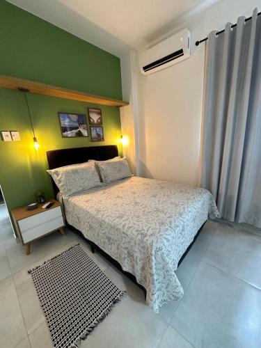 - une chambre avec un lit et un mur vert dans l'établissement Acolhedor apartamento na quadra da praia, à Rio de Janeiro