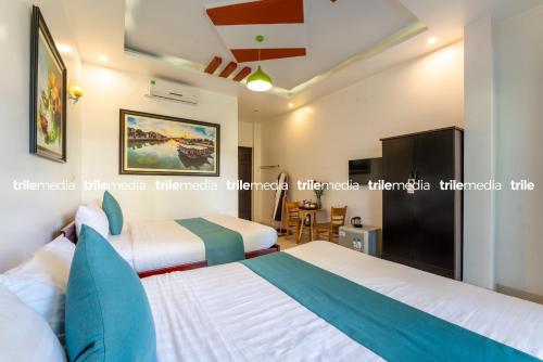 a bedroom with two beds and a tv at Rockmouse Centre River Villa Hoi An in Hoi An