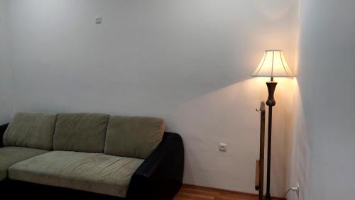 a living room with a couch and a lamp at Hotel Max Comfort in Kutaisi